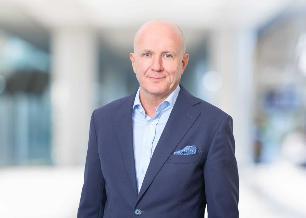 Petter Torp, head shot of a smiling man wearing a suit