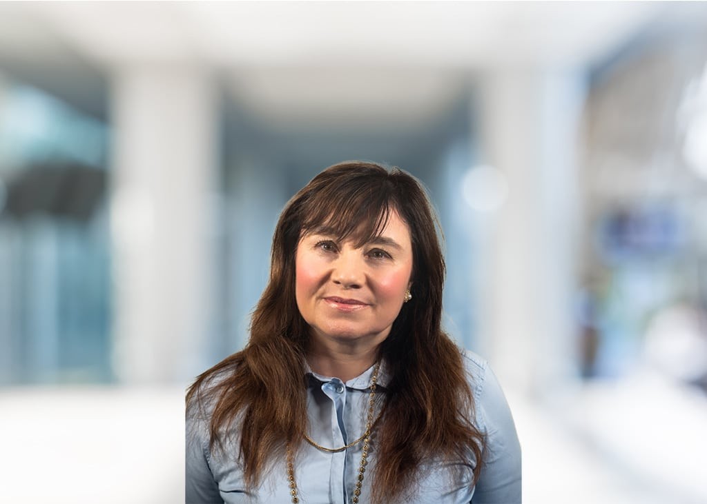Nicki Bumford, professional headshot of a smiling woman, wearing a blue shirt