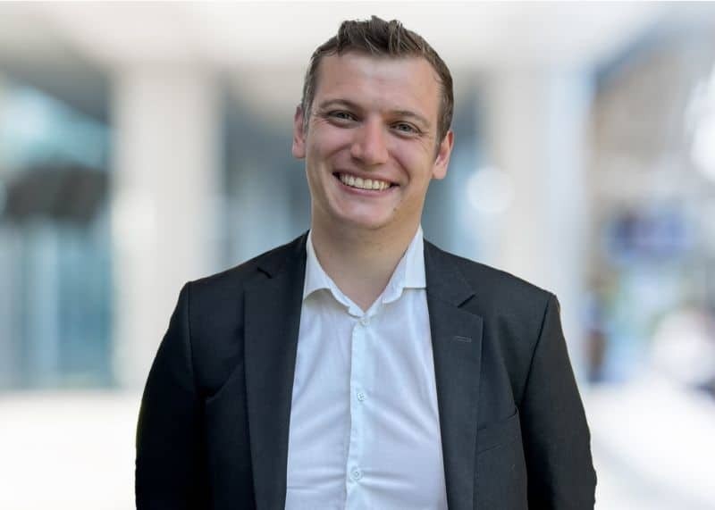 Christian Rud, professional headshot of a smiling man wearing a suit